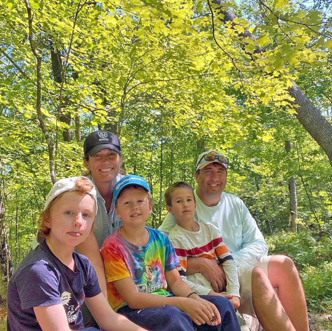 Jenny Peterson with her husband Chris and their three boys in the woods