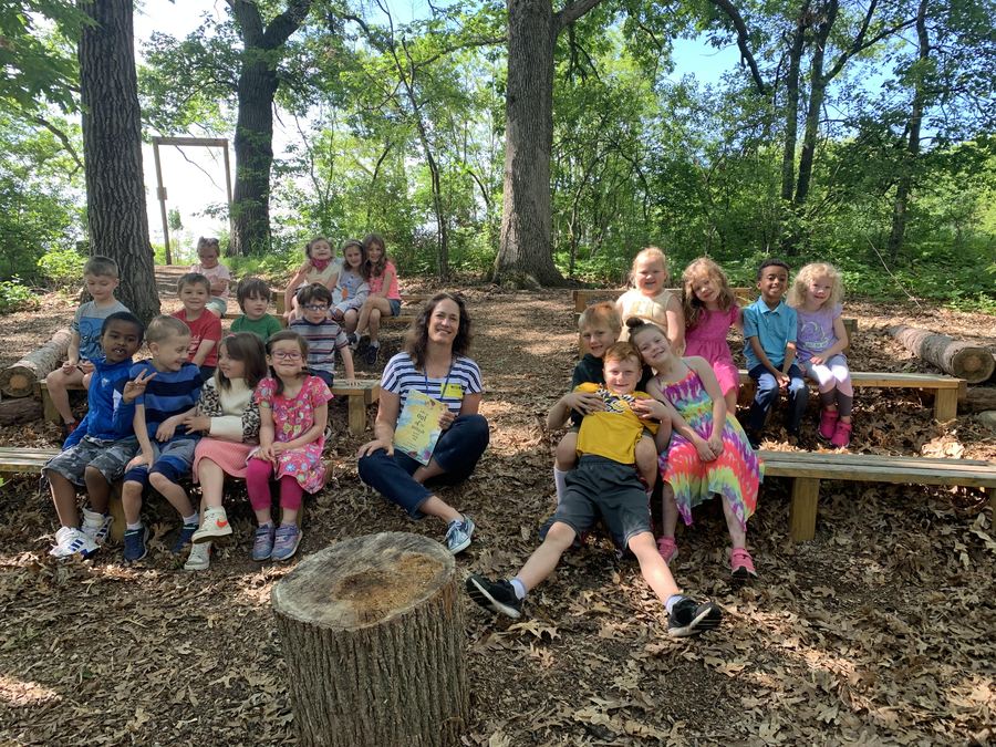 Jenny Peterson reading to a class of students in the outdoor classroom